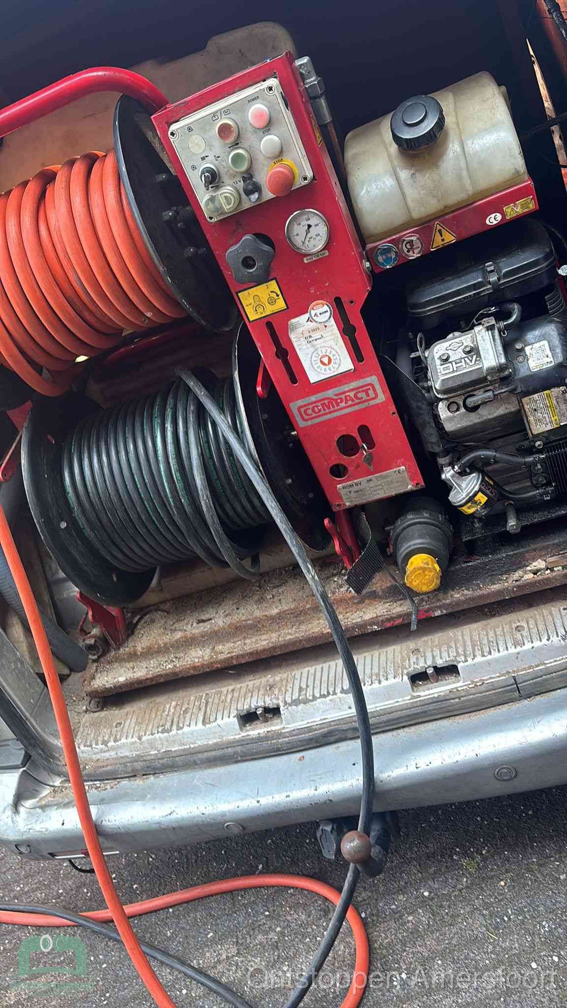 Een rood hogedruk-rioolreinigingstoestel in de laadbak van de bedrijfsbus, apparatuur voor een hardnekkige afvoerverstopping in Amersfoort