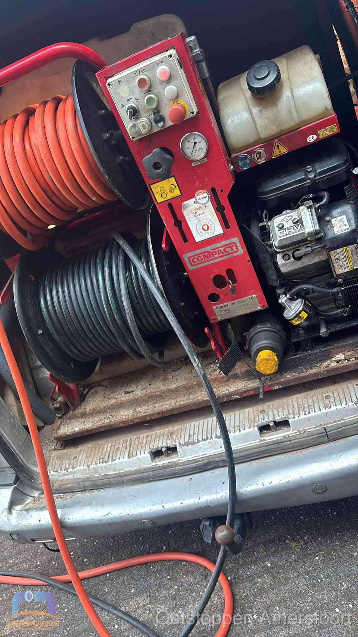 Een rood hogedruk-rioolreinigingstoestel met slangen in de laadbak van de bedrijfsbus, apparatuur voor een hardnekkige wc-verstopping in Amersfoort