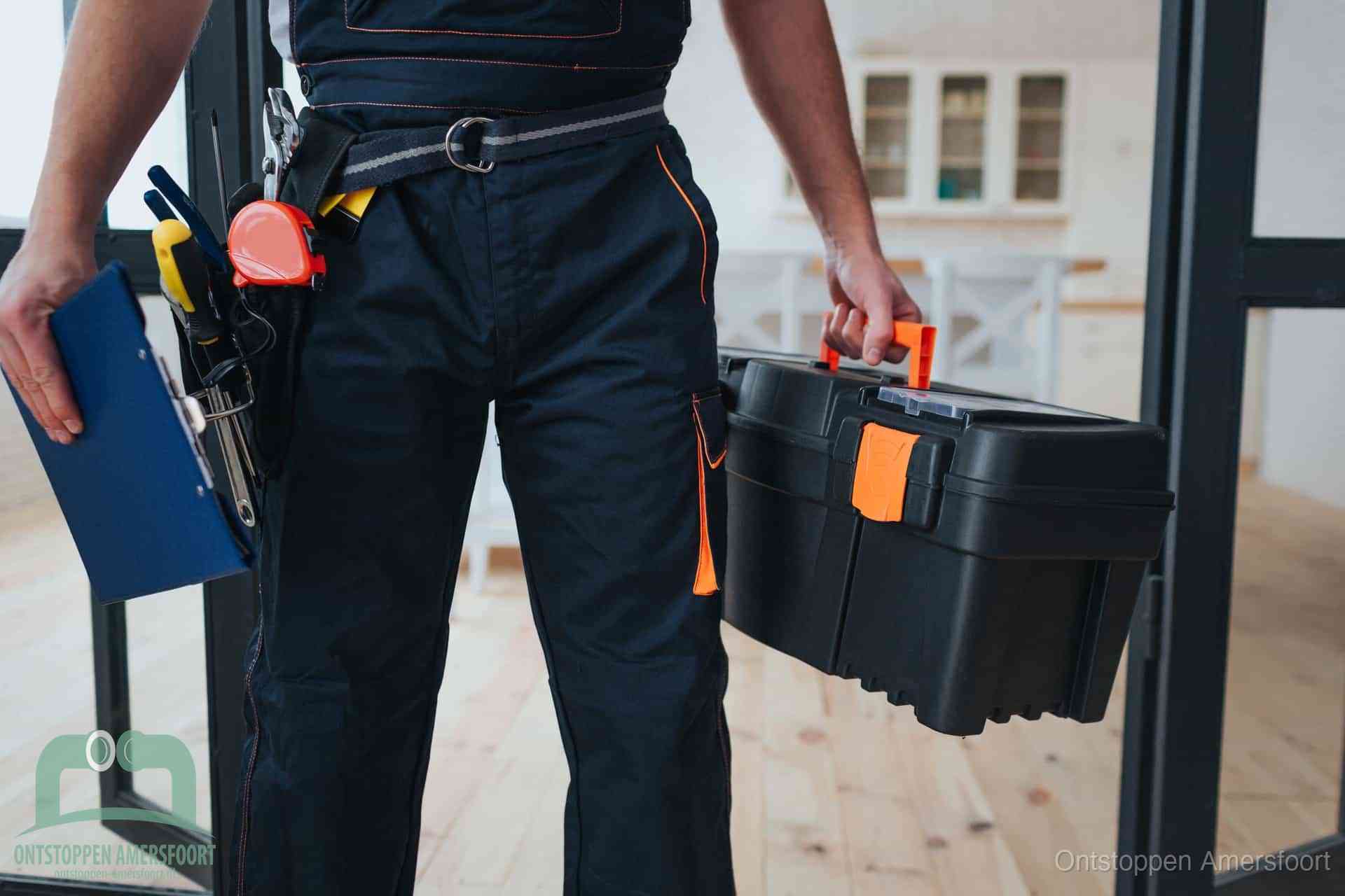 Een monteur met gereedschapsriem en klembord, klaar om een transparante prijs voor het afvoer ontstoppen in Amersfoort te geven