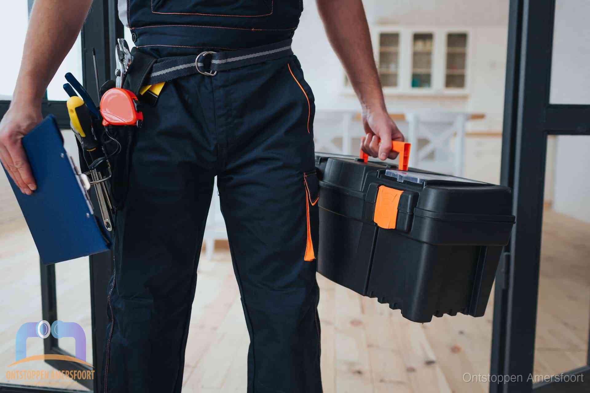 Een monteur met gereedschapsriem en klembord in een keuken, klaar om een transparante prijs voor het gootsteen ontstoppen in Amersfoort te geven