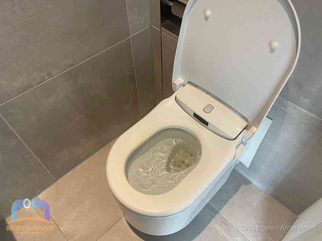 Een toiletpot vol troebel water met drijvend papier en restanten, de meest voorkomende oorzaak van een verstopte wc in Amersfoort