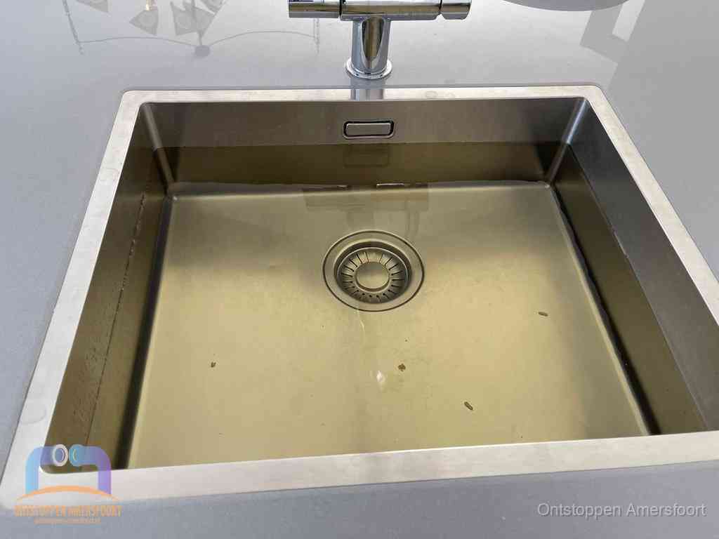 Stilstaand water in een rvs spoelbak dat niet wegloopt, een duidelijk signaal van een gootsteenverstopping in Amersfoort
