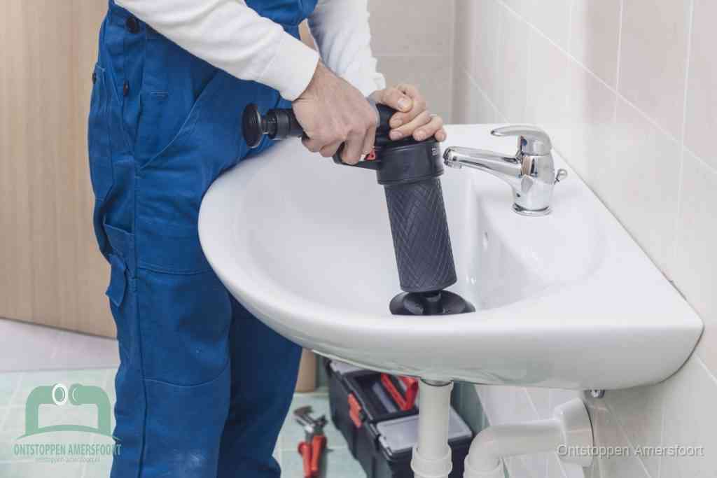 Een te ruwe doe-het-zelf poging met een hand-pomp op de afvoer van een badkamer-wastafel, een van de veelgemaakte fouten bij afvoer ontstoppen in Amersfoort